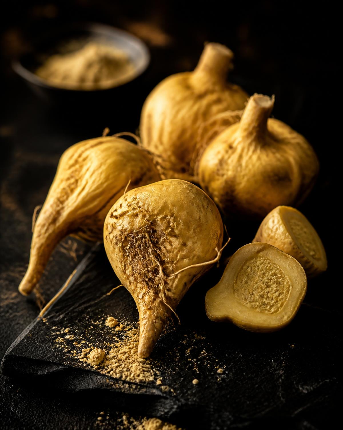 Raw golden maca roots on black slate
